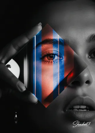 A woman's face fragmented into three vertical slices of black and white, neon red, and electric blue through a heavy crystal prism against a pitch-black background.