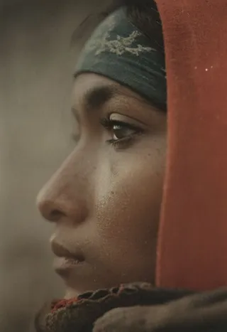 Closeup side profile of a freckled Navajo girl wearing a worn cowboy hat and red scarf, with cinematic moody lighting and shallow depth of field.