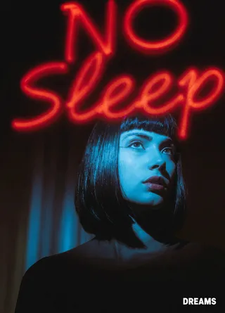 Portrait of a young woman with blunt bangs illuminated by blue light, standing in front of a red neon 'NO Sleep' sign in a dark urban night scene.