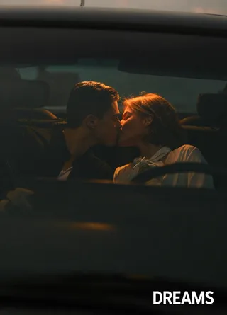Couple sharing a romantic kiss inside a dimly lit car at dusk, illuminated by warm interior light with soft focus and moody ambiance