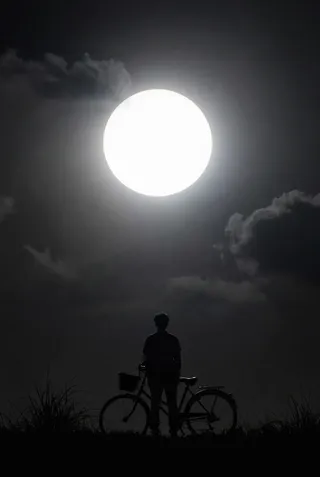 Silhouette of a person standing beside a bicycle under a colossal luminous eclipse in a monochromatic night sky with clouds.