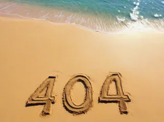 Number 404 written in the sand on a sunny beach near the water shore with gentle waves.
