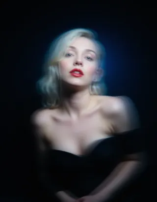 Blurry portrait of a blonde woman with red lips, motion blur effect on a black background, cinematic style with a blue tint