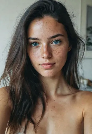 Close-up Instagram selfie of a gorgeous 23-year-old woman with blue eyes, freckles, black long hair, and natural lighting at home.