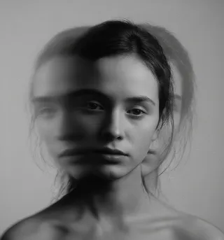 Black and white experimental portrait showing a woman's face with a melted double exposure effect and blurred duplicates on either side.
