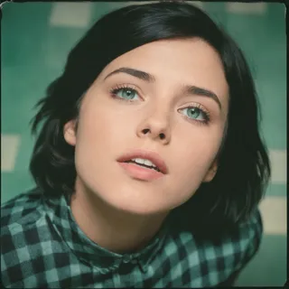 Close-up Polaroid-style portrait of a woman with green-blue eyes and black hair wearing a green and black checkered shirt, showcasing detailed skin texture on vintage analog film.