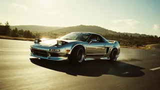Chrome Honda NSX car drifting on highway under bright daylight with film grain effect and high contrast lighting creating dramatic shadows