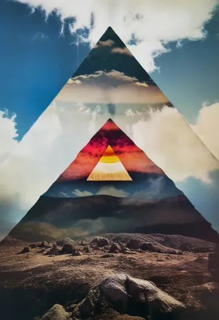 Surreal dark and moody mountain landscape with a double exposure effect forming a colorful all seeing eye pyramid, sun and moon behind clouds in the sky.