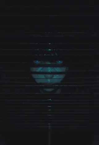 A glowing, mythical adult woman with glowing blue eyes peers through dark venetian blinds set in a dark, atmospheric scene with volumetric lighting effects.