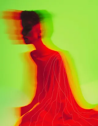 Abstract figure with a vividly red fabric featuring thin white lines, surrounded by motion blur and prismatic hues on a lime-green gradient background.