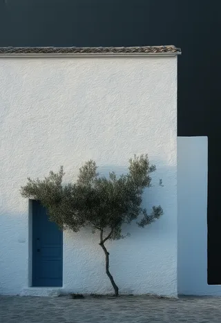 Minimalist white stucco Greek house with a blue door and an olive tree growing in front, set against a deep midnight black background with soft, diffused light.