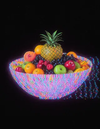 A glowing colorful fruit bowl featuring a pineapple and assorted fruits, rendered with retro glitch effects on a black background.