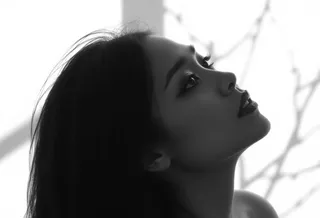 Black and white side profile portrait of a woman with soft lighting and contemplative expression