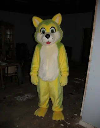 Anthropomorphic yellow and green wolf fursuit standing inside a dark abandoned house in a grainy flash photograph.
