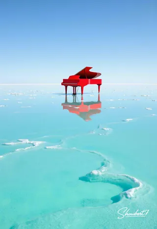 Bright red grand piano standing alone on a vast turquoise salt flat under a clear blue sky, perfectly reflected on the shallow water covering the salt surface.