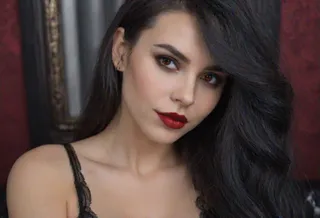 Photorealistic close-up portrait of a vampire woman with red eyes, black lipstick, and long dark hair, wearing black lace lingerie.